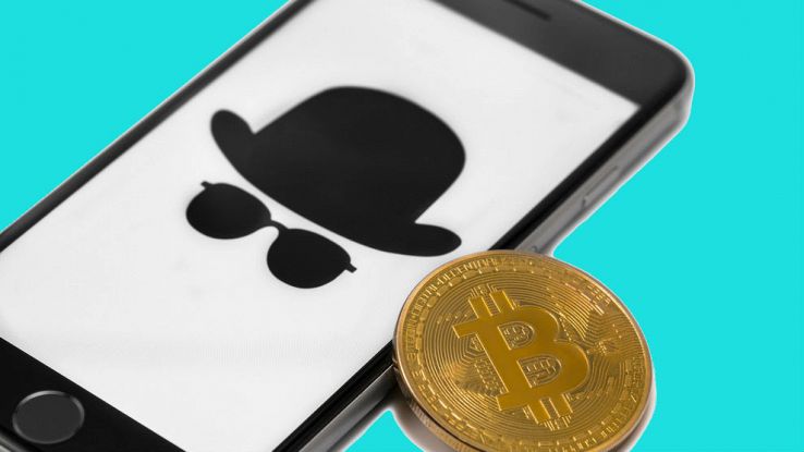 Un iPhone con una moneta di Bitcoin vicino allo schermo