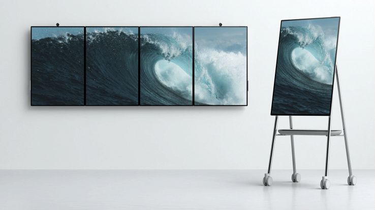 Quattro schermi Surface Hub 2 in fila più un Surface Hub 2 su un cavalletto