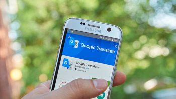 Un utente tiene in mano uno smartphone aperto sull'applicazione Google Translate