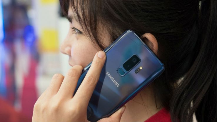 Una donna effettua una chiamata dal proprio smartphone