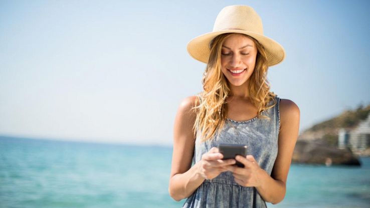 Una donna legge l'email in spiaggi
