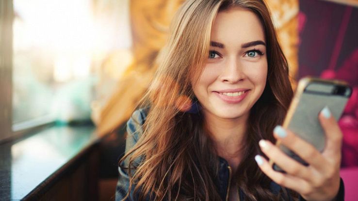 Una ragazza legge la posta sullo smartphone