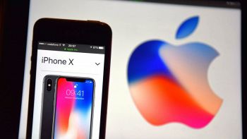 un iPhone X con sullo sfondo lo stemma Apple