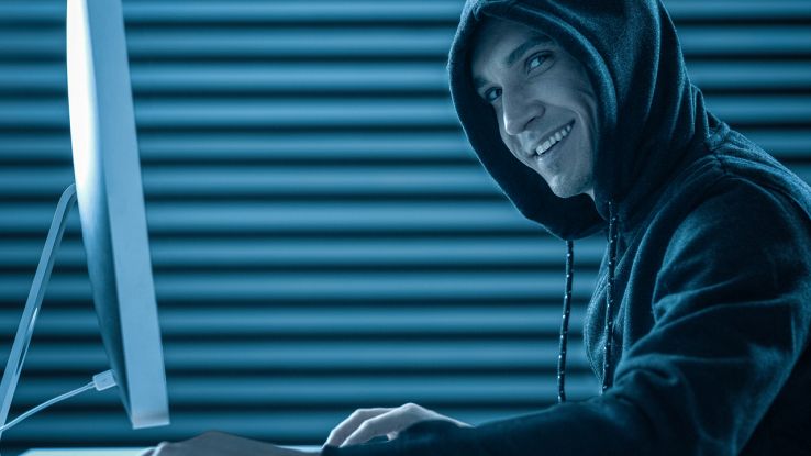 Un hacker sorride davanti a un PC