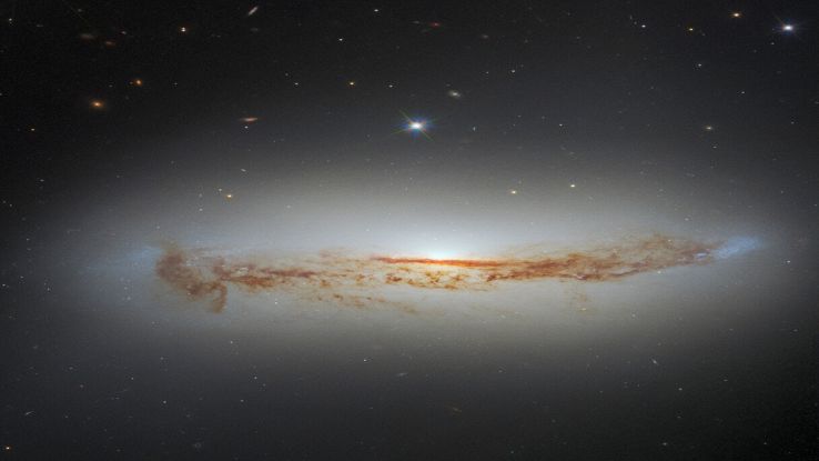 Cumuli di polvere cosmica oscurano il cuore di una galassia: la foto di Hubble
