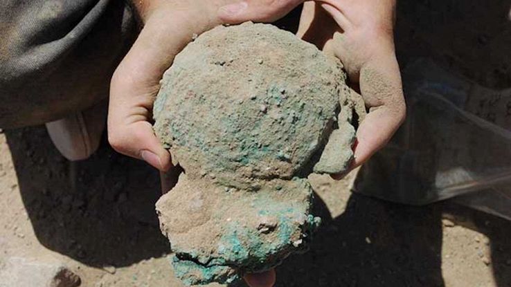 Lingotto di rame tenuto tra le mani da un archeologo