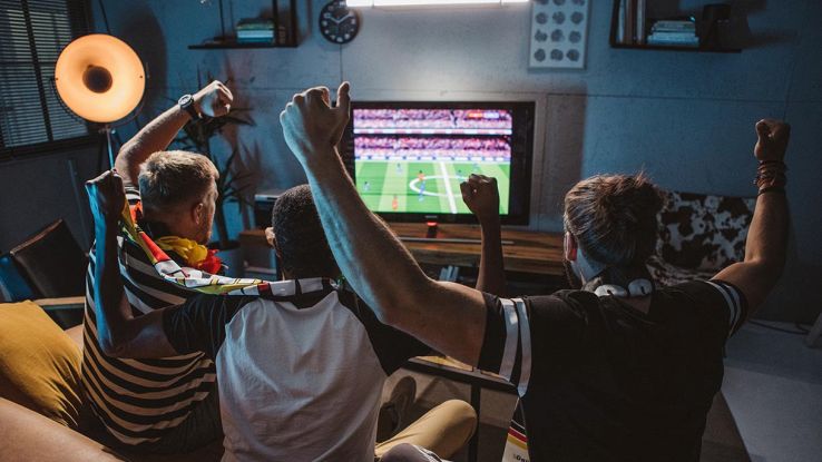 tifosi davanti a un televisore a vedere una partita di calcio