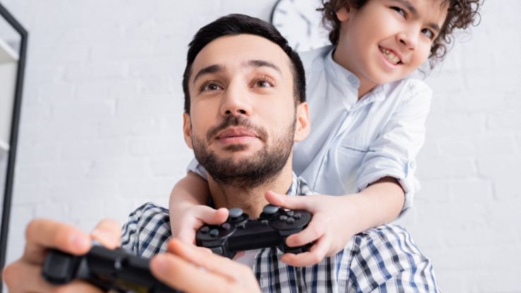 Un papà e suo figlio che giocano ai videogames per l festa del papù