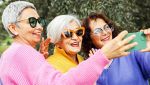 Tre signore di circa 60 anni si scattano una foto con lo smartphone da postare sui social