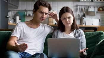 Una coppia guarda sconcertata lo schermo del pc