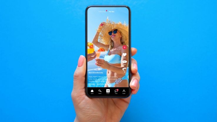 Utente guarda una influencer al mare su TikTok