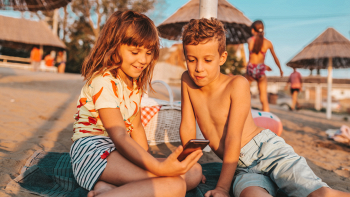 bambini intenti a giocare con smartphone a ferragosto