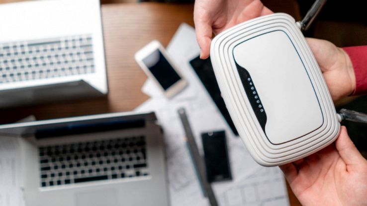 Router per sistemi mesh Wi-Fi 6/6E tenuto in mano, soluzione per copertura rete domestica ad alte prestazioni