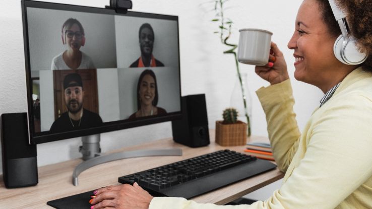 Persona in smart working che partecipa a una video call con webcam su monitor