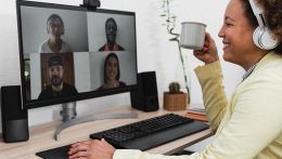 Persona in smart working che partecipa a una video call con webcam su monitor