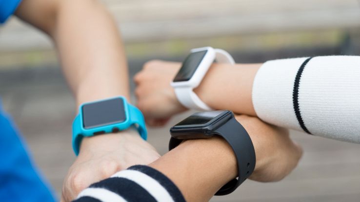 Smartwatch al polso di tre amici, fitness tracker per attività e salute.
