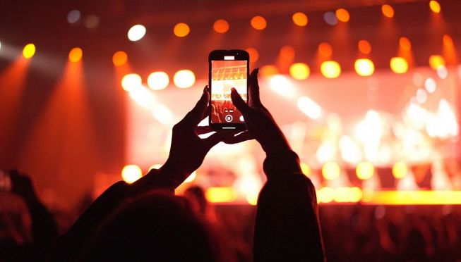 Un fan ad un concerto con telefono in mano
