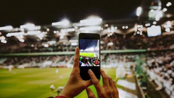 Un fan allo stadio con telefono in mano