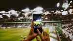Un fan allo stadio con telefono in mano