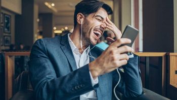 Un uomo ride al cellulare