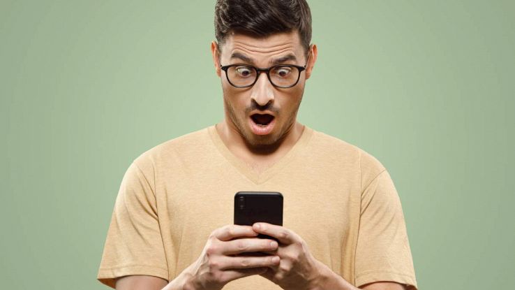 Un ragazzo guardo lo smartphone stupito