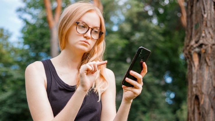 Ragazza confusa che valuta un SMS truffa
