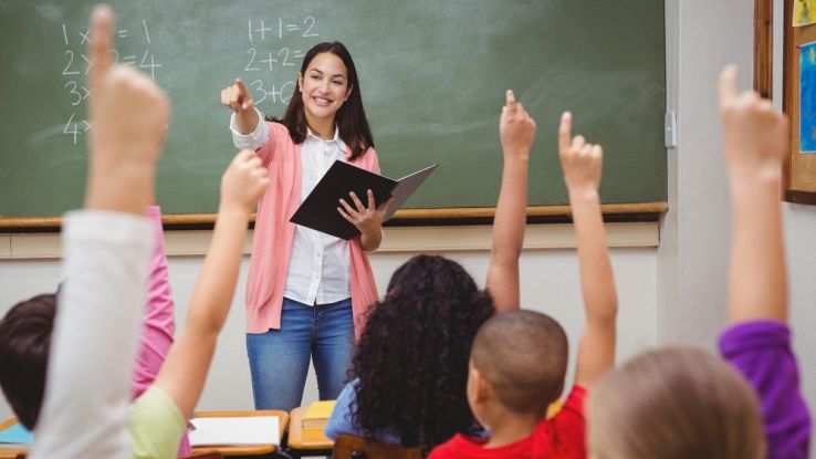 Docente davanti alla lavagna con bambini nell’aula