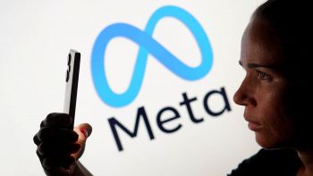 Persona impugna uno smartphone sfondo logo Meta