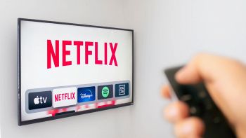 Schermo TV appeso al muro e logo Netflix