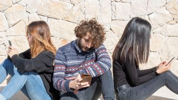 Ragazzi vicini che si ignorano guardando lo smartphone