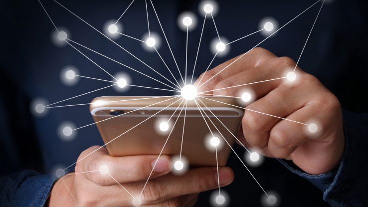 Uomo tiene in mano uno smartphone e connessioni