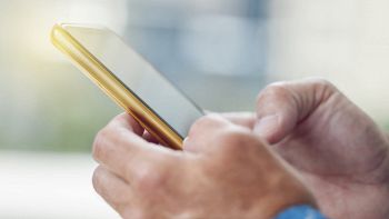 Mani di uomo che reggono uno smartphone dorato
