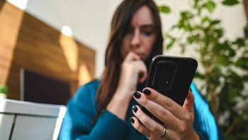 Una donna preoccupata guarda lo smartphone