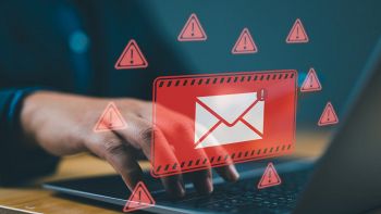 Un uomo digita sulla tastiera di un pc con alert di posta elettronica