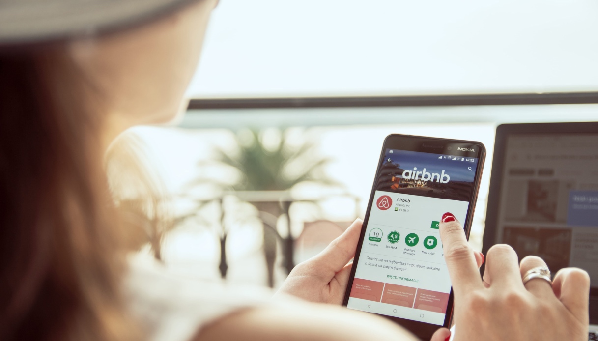 https://wips.plug.it/cips/tecnologia/cms/2026/06/schermata-smartphone-con-airbnb-donna-prenota.jpg