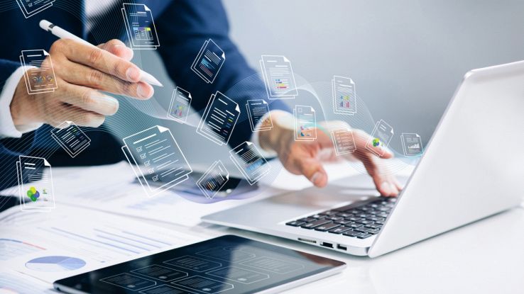 Un uomo gestisce una grande quantità di documenti dal suo PC