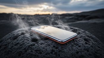 Smartphone poggiato su pietra lavica fumante