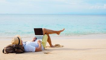 Uomo con un PC in spiaggia