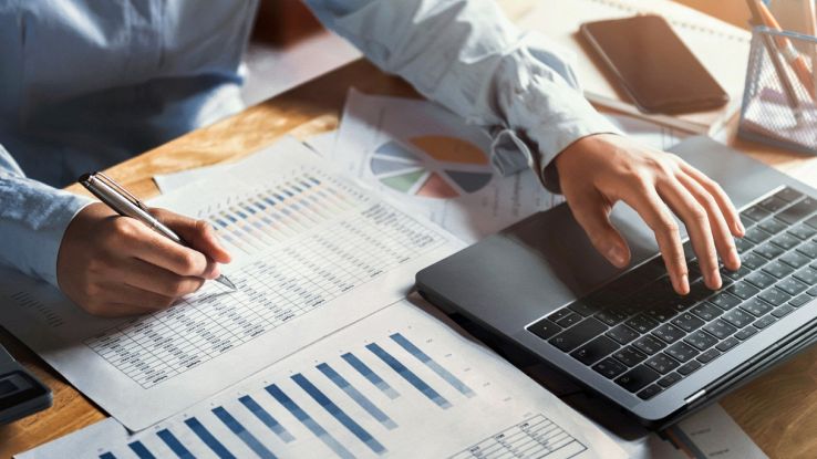 Un uomo controlla delle tabelle e dei grafici con un PC
