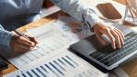 Un uomo controlla delle tabelle e dei grafici con un PC
