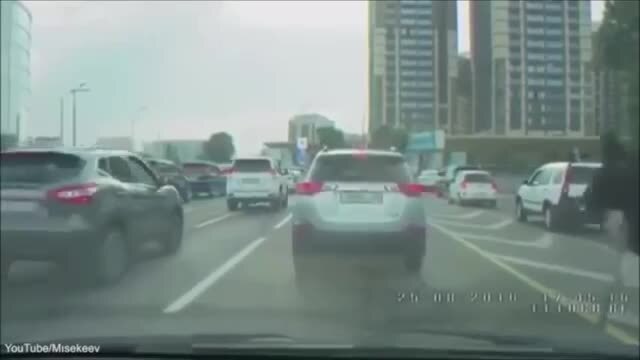 Uomo sullo struzzo supera la coda di auto