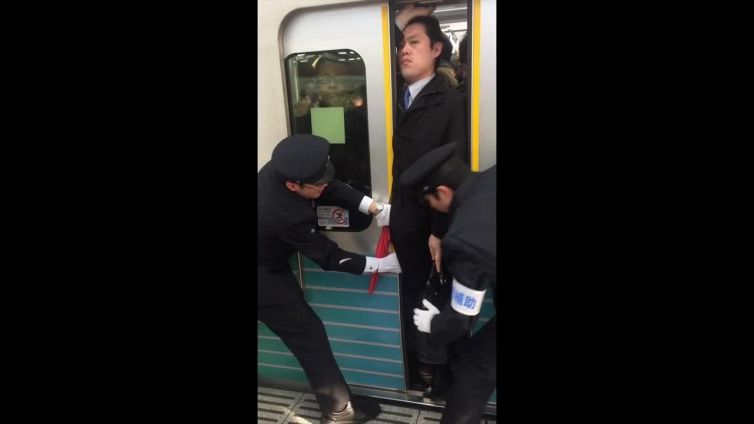 Schiacciato nella metro di Tokyo: l'uomo resta impassibile