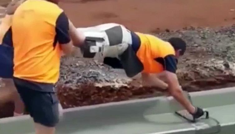 La 'carriola umana' degli operai per costruire il marciapiede