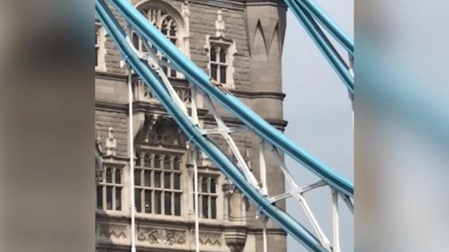 Un uomo nudo prende il sole sul Tower Bridge di Londra