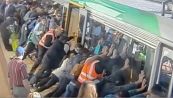 Resta incastrato nel "gap" della metro, i passeggeri sollevano il vagone per liberarlo