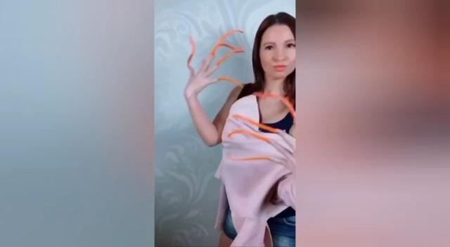 La donna con le unghie più lunghe al mondo mostra come indossa la maglietta