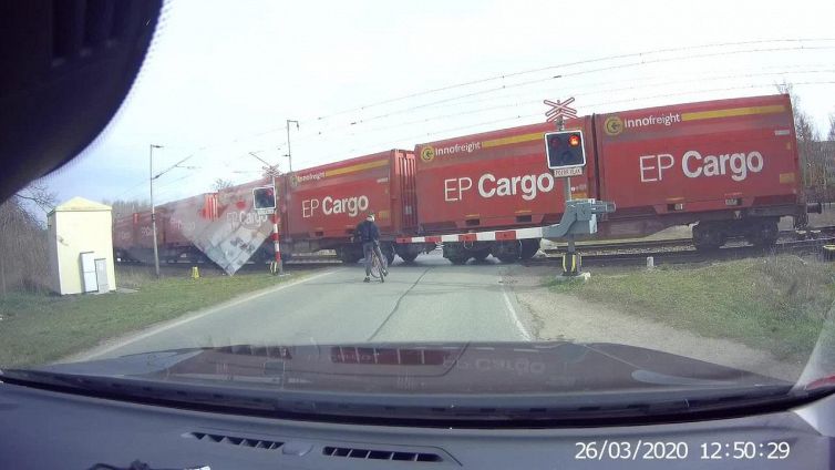 Il ciclista impaziente al passaggio a livello sfiora il treno in arrivo