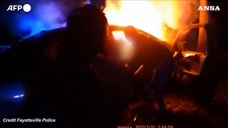 Poliziotti salvano due persone da auto in fiamme