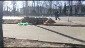 Ucraina, un uomo scava una trincea in una strada principale di Kiev