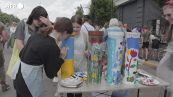 A Bucha adolescenti e artisti dipingono resti di munizioni e auto bruciate